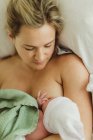 Vista aerea della donna adulta che allatta al seno figlia neonata a letto — Foto stock