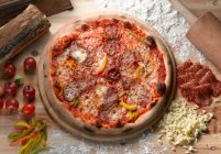 Pizza mit Fleisch und Gemüse auf Holztisch — Stockfoto