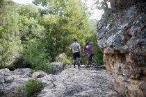 Giovane coppia appoggiata su mountain bike su roccia — Foto stock