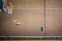 Баскетбол вот-вот провалится через баскетбольную сеть — стоковое фото