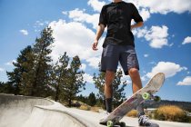 Neck down view of young male skateboarder in skate park, Mammoth Lakes, California, EUA — Fotografia de Stock