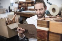 Чоловік з кишені перевіряє дерев'яні вироби на заводі — стокове фото