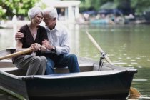 Старшая пара, обнимающаяся на лодке — стоковое фото