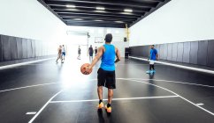 Visão traseira do jogador de basquete masculino em pé com bola na prática de basquete — Fotografia de Stock