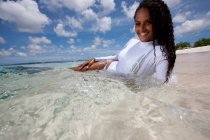 Jeune femme se relaxant en eau peu profonde — Photo de stock