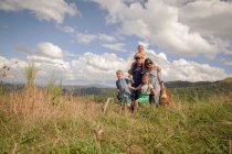 Семья идет вместе через поле — стоковое фото