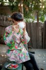 Молодая женщина сидит на улице, пьет горячий напиток — стоковое фото