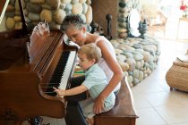 Бабуся і онук грають на піаніно — стокове фото