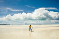 Uomo che cammina lungo la spiaggia — Foto stock
