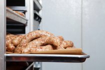 Raw sausages ready to cook on baking tray — Stock Photo