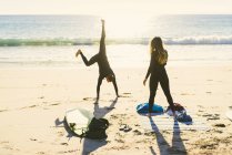 Surfing couple cartwheeling on Newport Beach, California, USA — Stock Photo