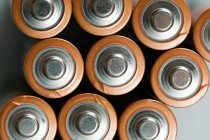 Top view of Batteries placed in a row on grey surface — Stock Photo
