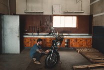 Man repairing bike in workshop — Stock Photo