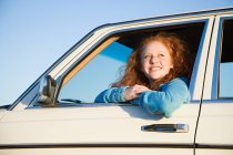Молодая женщина высунулась из окна машины — стоковое фото