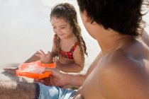 Un père et sa fille jouant sur une plage — Photo de stock