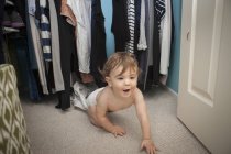 Дитячий хлопчик повзає, виходить з гардеробу — стокове фото