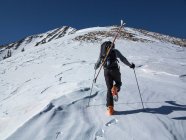 Esquiador de fondo trekking cuesta arriba - foto de stock