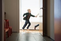Двоє дітей біжать повз дверний проріз — стокове фото