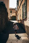 Vista posteriore del ragazzo che corre lungo la stradina, Luino, Lombardia, Italia — Foto stock