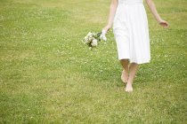 Image recadrée de la mariée marchant sur l'herbe — Photo de stock