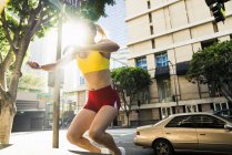 Mujer joven haciendo ejercicio al aire libre, saltando a la pared - foto de stock