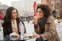 Femmes mangeant ensemble au café sur le trottoir — Photo de stock