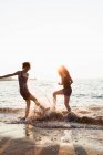 Mulheres brincando em ondas na praia — Fotografia de Stock