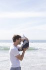 Отец держит мальчика, лицом к лицу, на пляже — стоковое фото