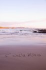 Costa Rica escrito en arena sobre bea - foto de stock