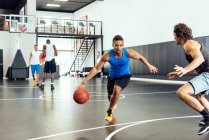 Dos jugadores de baloncesto practican defensa de pelota en cancha de baloncesto - foto de stock