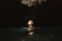 Mulher na caverna cheia de água com os olhos fechados, Oahu, Havaí, EUA — Fotografia de Stock