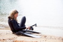Mergulhador feminino adulto médio se preparando para mergulhar na praia — Fotografia de Stock