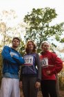Giovani amici in abbigliamento sportivo in piedi insieme nella foresta — Foto stock