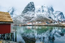 Gebäude und schneebedeckte Berge, Reine, Lofoten, Norwegen — Stockfoto
