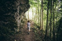 Задній вид хлопчик ходьба грунтовій дорозі в лісі, Блуденц, Форарльберг, Австрія — стокове фото