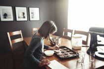 Молода дівчина прикрашає незапечене печиво на випічці — стокове фото