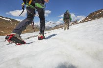 Casal jovem caminhando até gelo na geleira Val Senales, Val Senales, Tirol do Sul, Itália — Fotografia de Stock