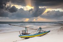 Gestrandetes Fischerboot und dramatischer Himmel bei Sonnenuntergang, Taiba, Ceara, Brasilien — Stockfoto