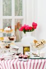 Tavola servita con diversi dolci, torte e tè a casa — Foto stock