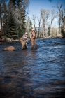 Pescadores tobillo profundo en la pesca con mosca del río, Colorado, EE.UU. - foto de stock