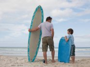 Pai e filho com prancha de surf e bodyboard — Fotografia de Stock