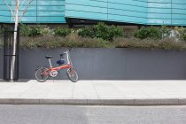 Дитячий велосипед з шоломом припаркований на тротуарі — стокове фото