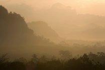 Silhouettes of hills in foggy landscape — Stock Photo