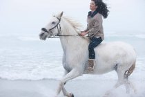 Femme équitation cheval sur la plage — Photo de stock