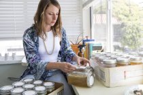 Women labeling jars at home — Stock Photo