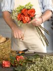 Abgeschnittenes Bild des Blumenhändlers, der Blumenstrauß im Geschäft bindet — Stockfoto