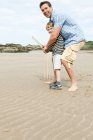 Pai e filho jogando críquete na praia — Fotografia de Stock