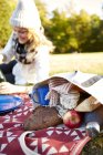 Junge Frau bei Picknick im Park liegend — Stockfoto