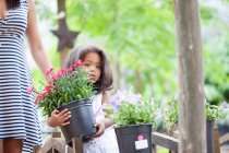Mädchen trägt Pflanzkübel im Freien — Stockfoto