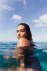 Жінка в море дивлячись на плече на камеру, Оаху, Гаваї, США — стокове фото